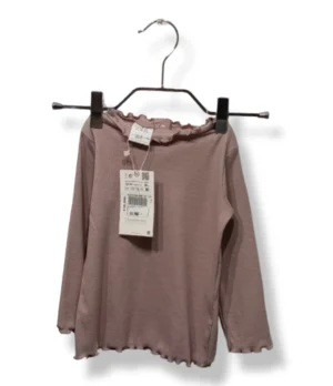 Polera de algodón acanalado color rosa suave, con delicado diseño de ondas en cuello, puños y basta.